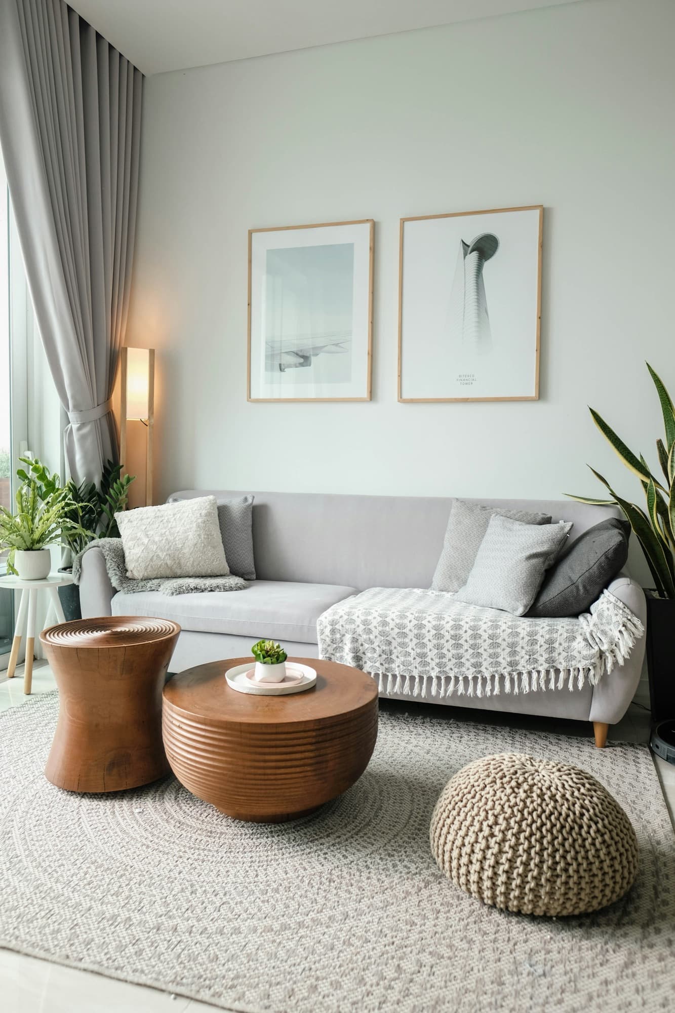 A bright apartment living room with a sofa, plants and a large window